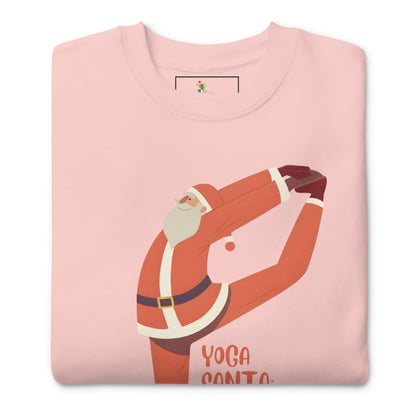 Folded pink t-shirt with a graphic of Santa Claus doing yoga on a white background