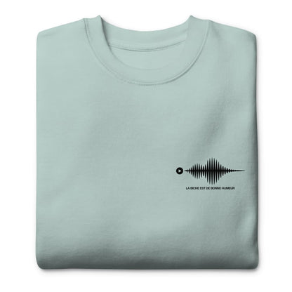 Folded light blue sweatshirt with a black graphic design on a white background