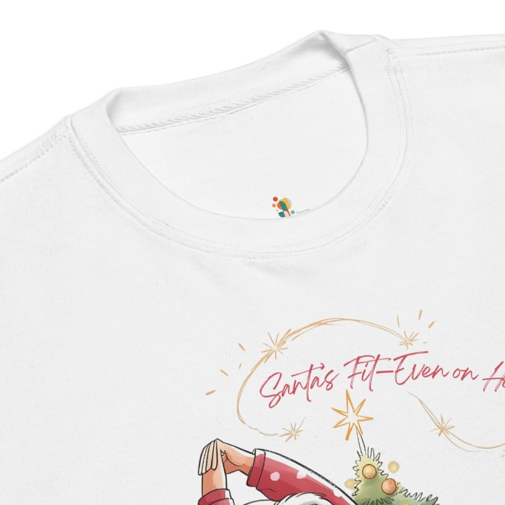 White shirt with a festive design featuring a person in a red outfit and text 'Santa's Fit Even on Christmas'.
