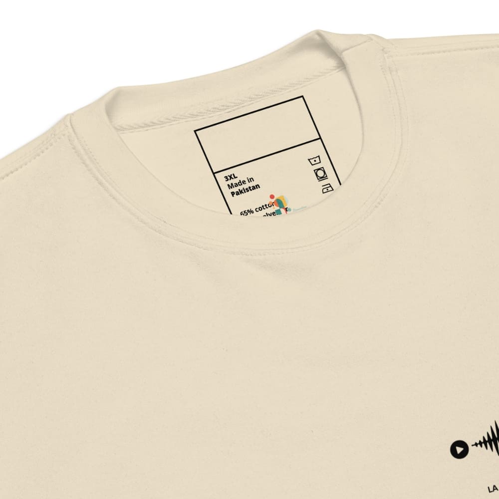 Close-up of a beige t-shirt with a label on the collar displaying fabric information.