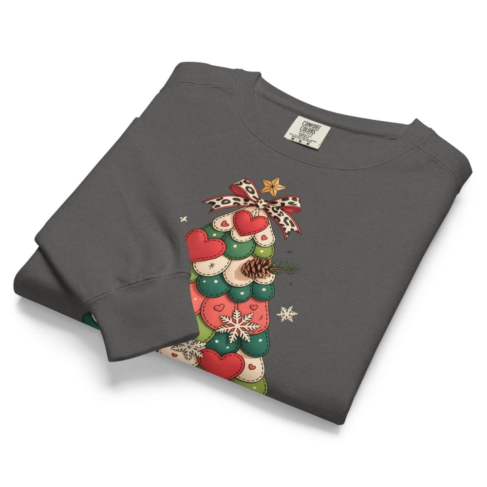 Folded gray sweatshirt with a Christmas tree design on a white background