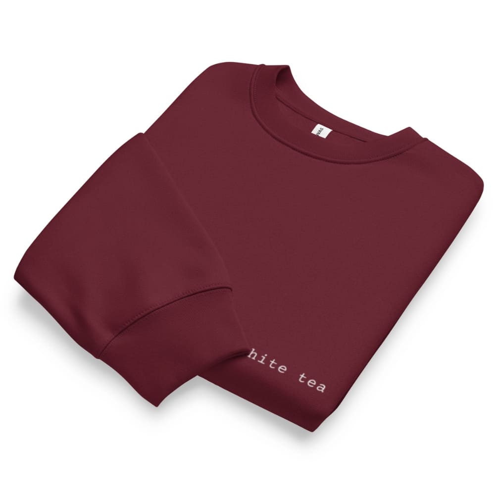 Folded maroon sweatshirt with 'hite tea' text on a white background