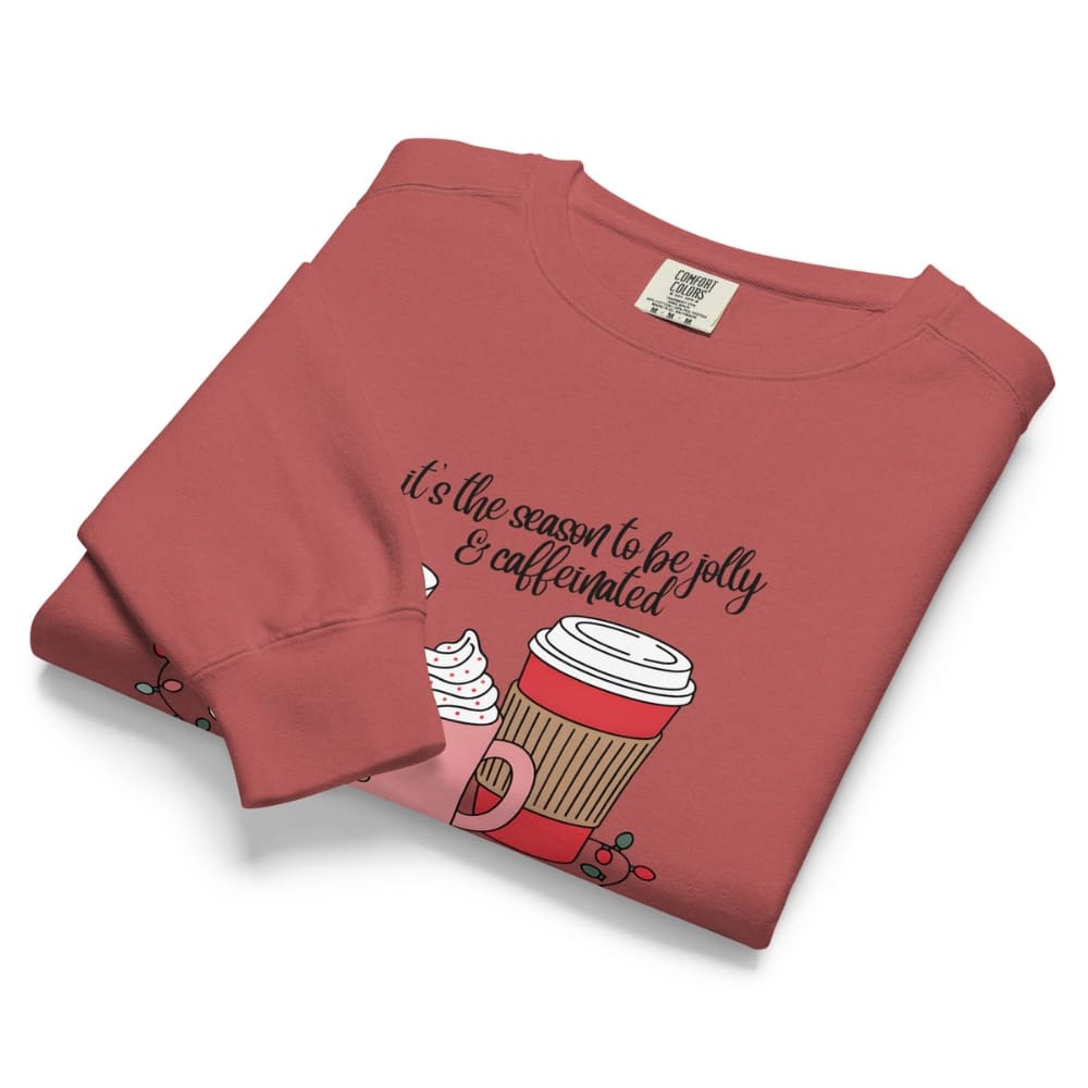 Folded red sweatshirt with a coffee cup graphic and text on a white background