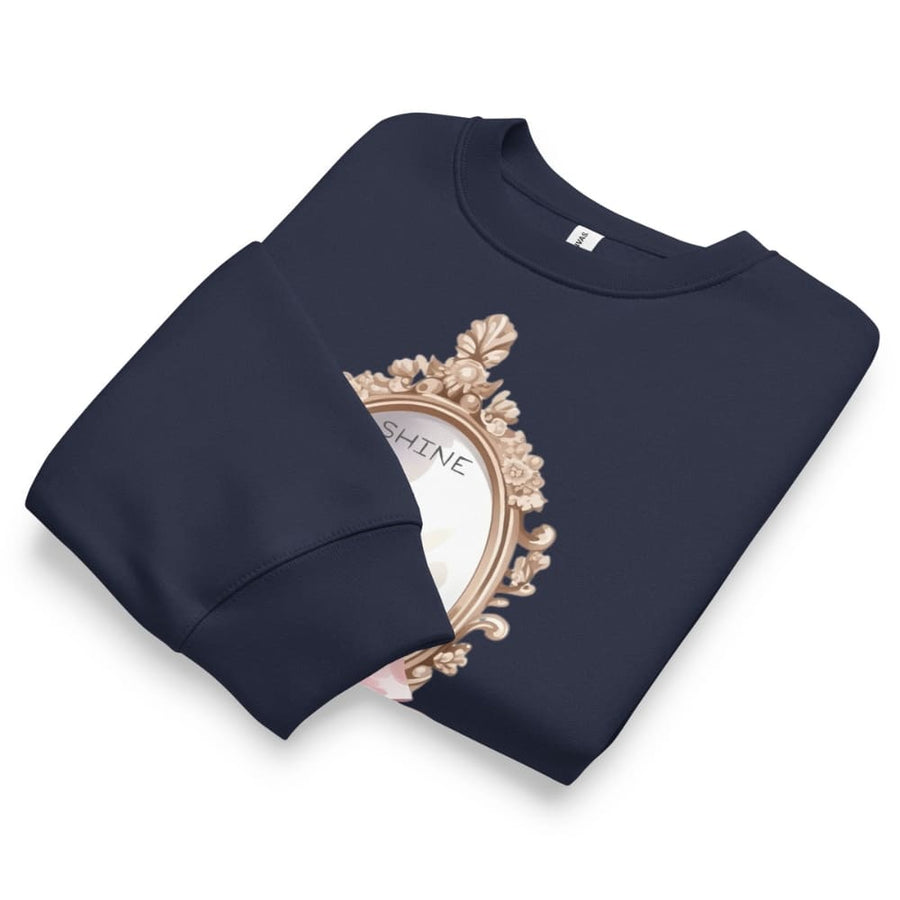 Navy blue sweatshirt with decorative emblem and 'SHINE' text on a white background