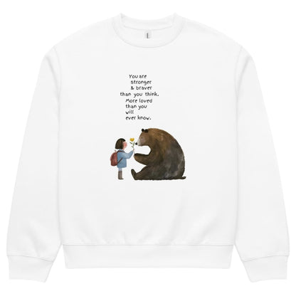 White sweatshirt with a graphic of a girl and bear holding hands and text on a white background