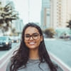 Person wearing glasses with a blurred city street background