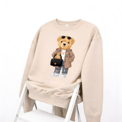 Beige sweatshirt with a teddy bear graphic on a white background