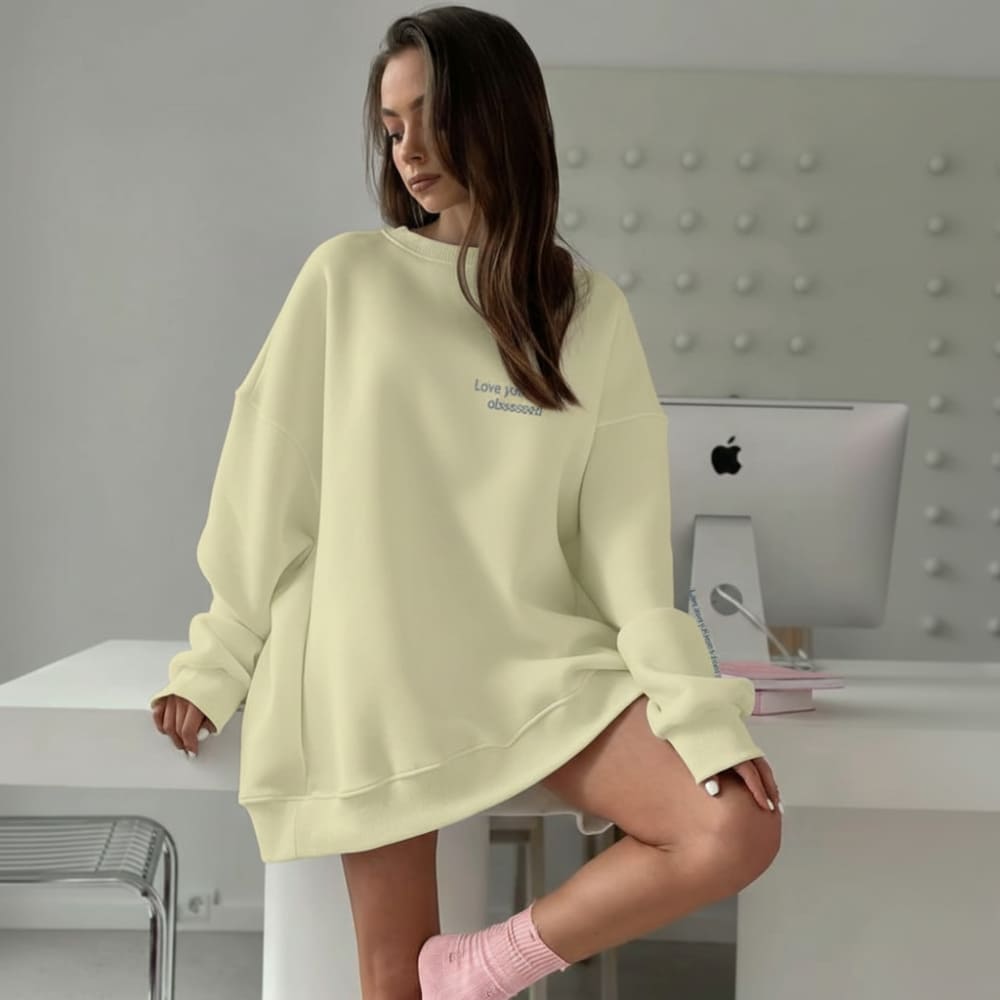 Woman wearing a light yellow oversized sweatshirt in an office setting