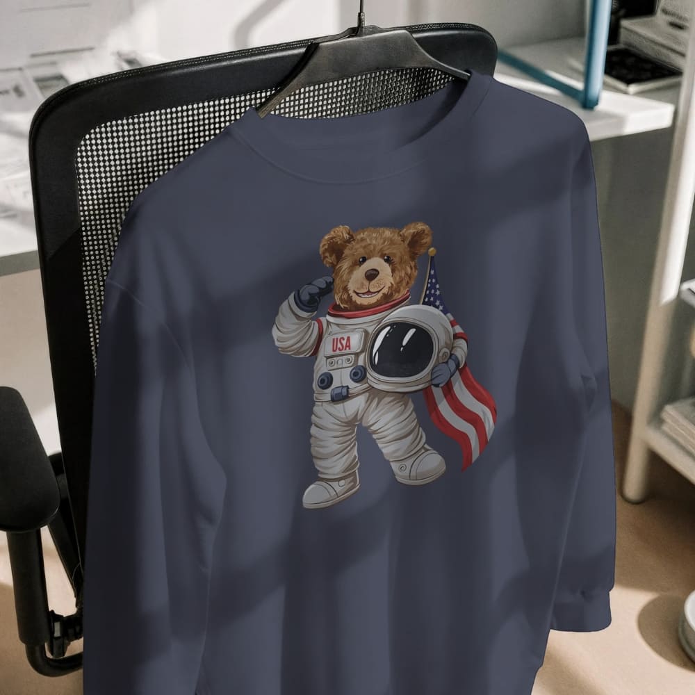 Navy blue sweatshirt with an astronaut bear design on a chair.