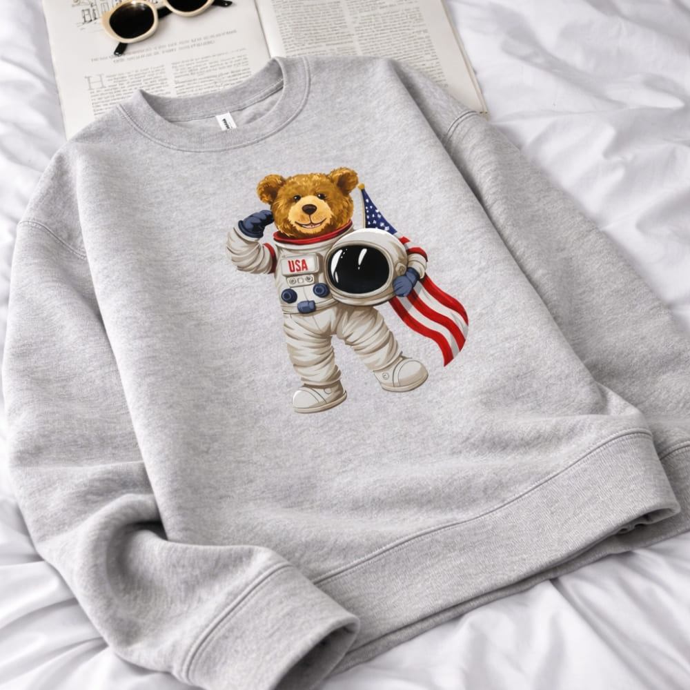Gray sweatshirt with a teddy bear astronaut design on a white surface