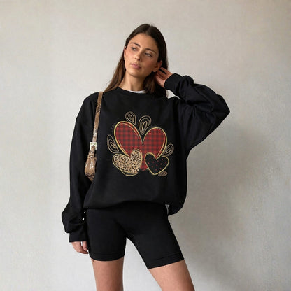 Woman wearing a black sweatshirt with heart design against a plain background