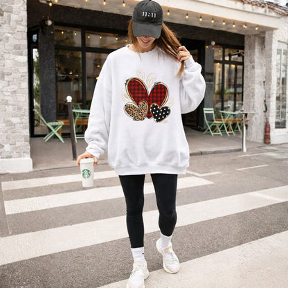 Person wearing a white sweatshirt with colorful designs, black leggings, and white sneakers, holding a Starbucks cup on a street.