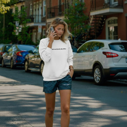 Woman talking on a phone while walking on a street with parked cars and buildings in the background