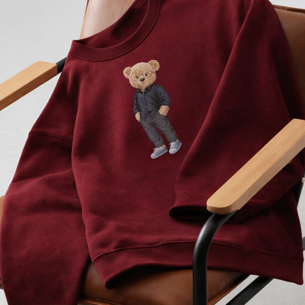 Maroon sweatshirt with embroidered bear design on a chair