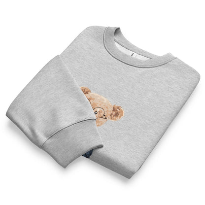 Folded gray sweatshirt with a teddy bear design on a white background