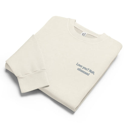 Folded beige sweatshirt with text on a white background