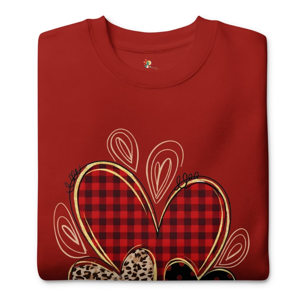 Folded red sweatshirt with a plaid heart design on a white background