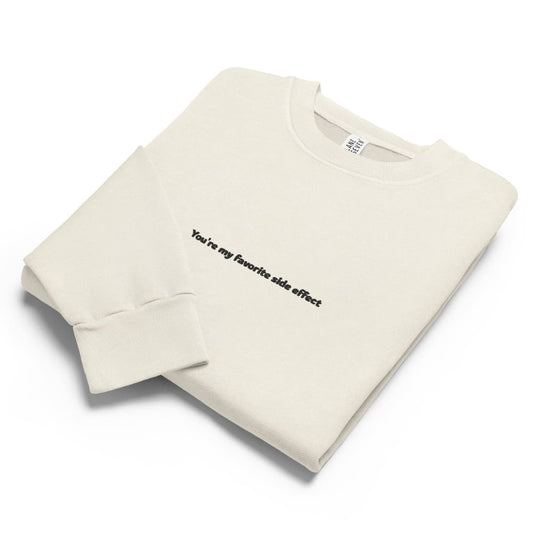 Folded beige sweatshirt with text on a white background