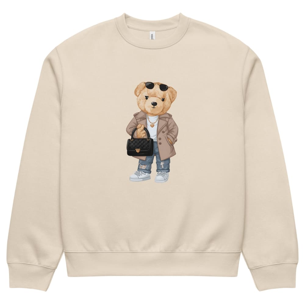 Beige sweatshirt with a teddy bear graphic holding a handbag on a white background