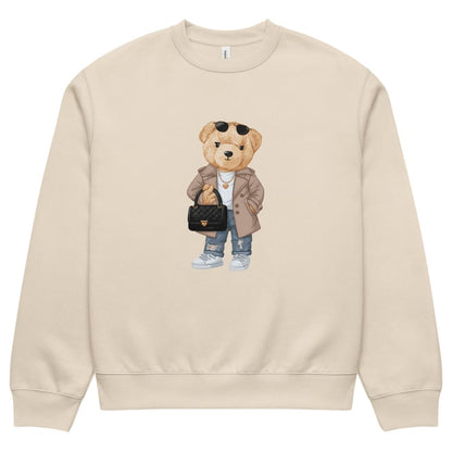 Beige sweatshirt with a teddy bear graphic holding a handbag on a white background