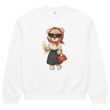 White sweatshirt with a teddy bear design holding a glass of champagne and a handbag on a white background