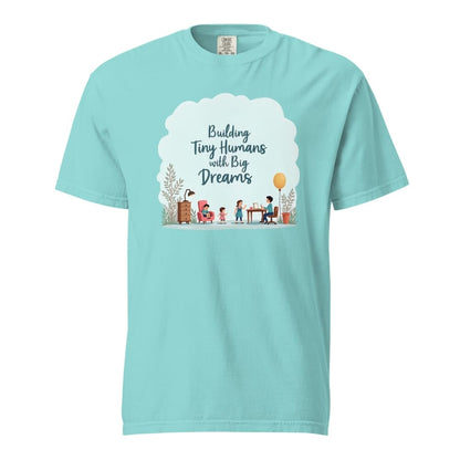 Illustrated t-shirt design with the quote "Building Tiny Humans with Big Dreams" surrounded by a family parenting scene