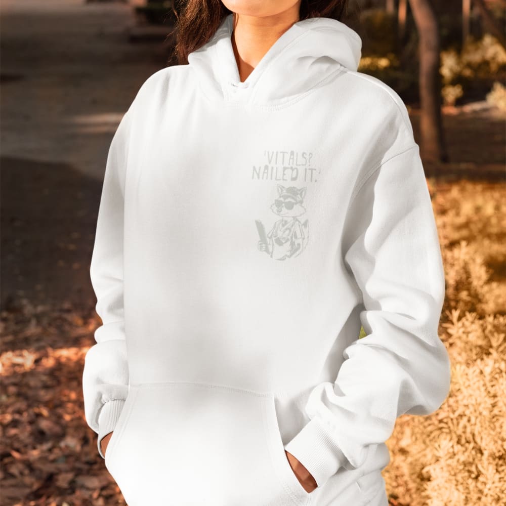 Raccoon nurse graphic wearing scrubs and sunglasses holding a clipboard under the quote “Vitals? Nailed It.” – printed on a black Cotton Heritage hoodie