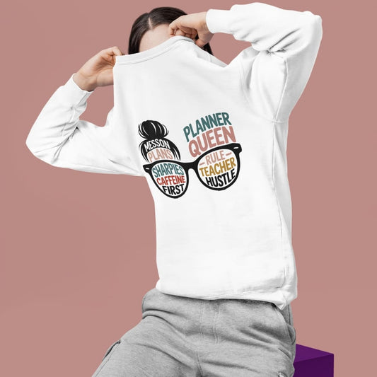 Person wearing a white sweatshirt with colorful text and graphics on a brown background