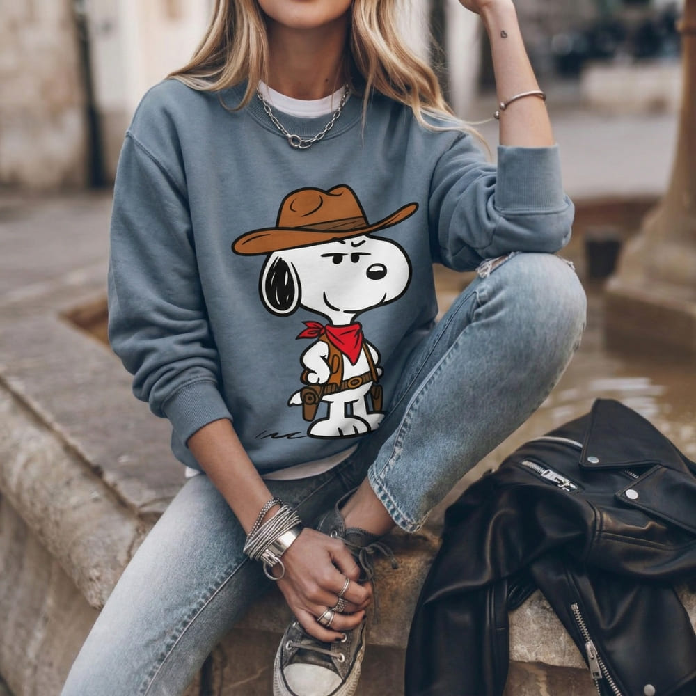 Person wearing a blue sweatshirt with a cartoon character sitting on steps.