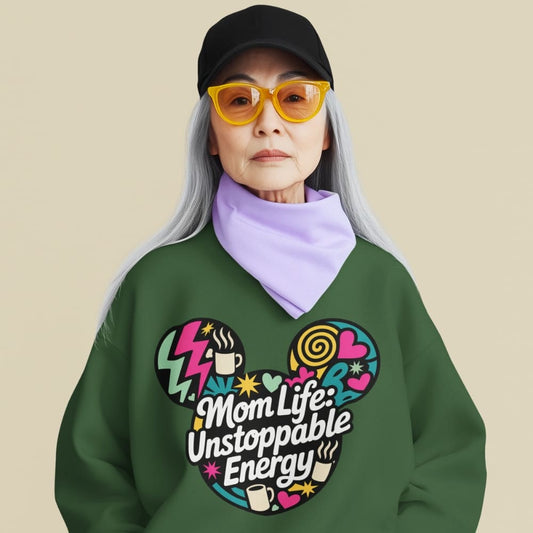 Person wearing a green sweatshirt with colorful design and text, yellow sunglasses, and a black cap on a beige background.