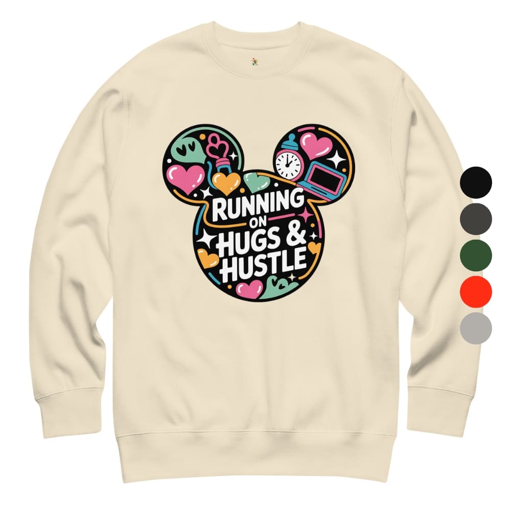 Beige sweatshirt with colorful graphic design and text 'Running on Hugs & Hustle' on a white background.