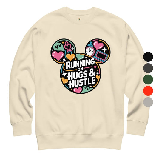 Beige sweatshirt with colorful graphic design and text 'Running on Hugs & Hustle' on a white background.
