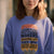 Person wearing a blue sweatshirt with a printed design and text.