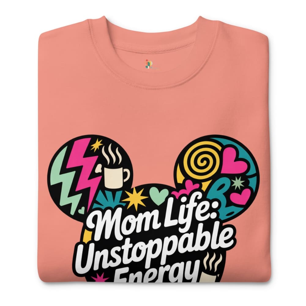 Folded pink t-shirt with colorful graphic and text 'Mom Life: Unstoppable Energy' on a white background