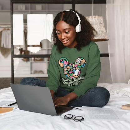 Person wearing headphones and a green sweatshirt with a laptop on a bed