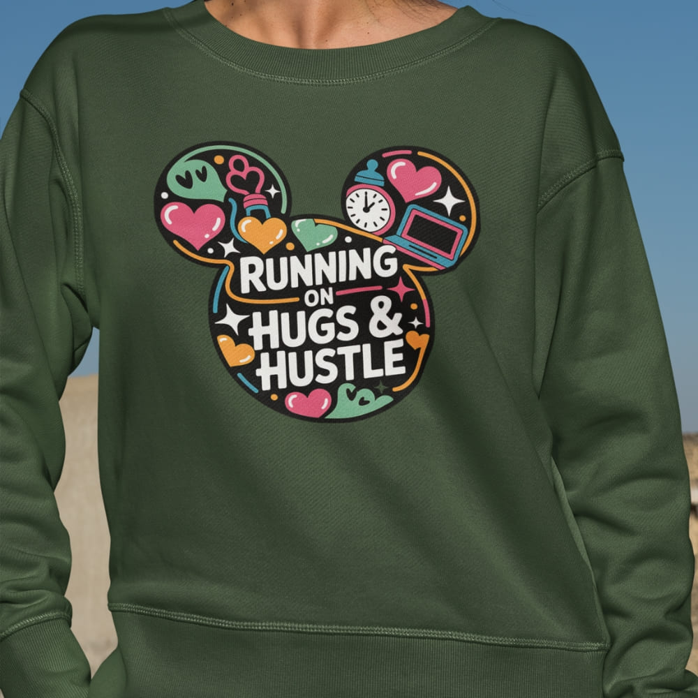 Green sweatshirt with colorful design and text 'Running on Hugs & Hustle' on a blue sky background