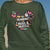 Green sweatshirt with colorful design and text 'Running on Hugs & Hustle' on a blue sky background