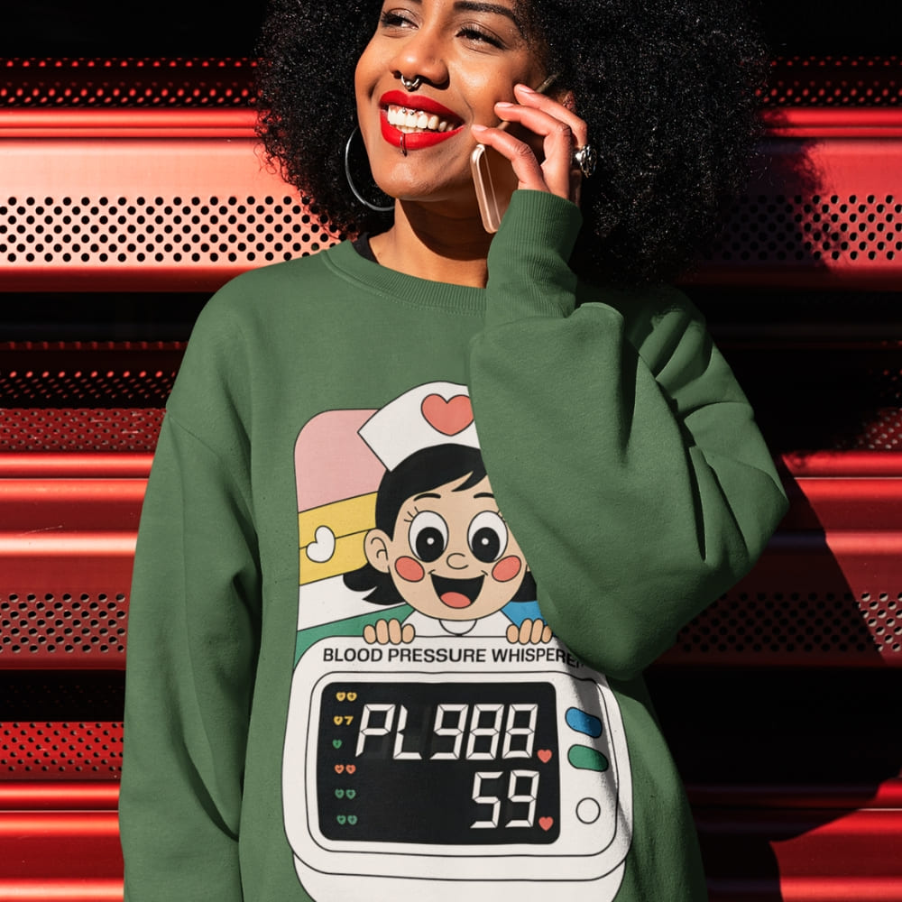 Person wearing a green sweatshirt with a cartoon character design, standing against a red and black background.