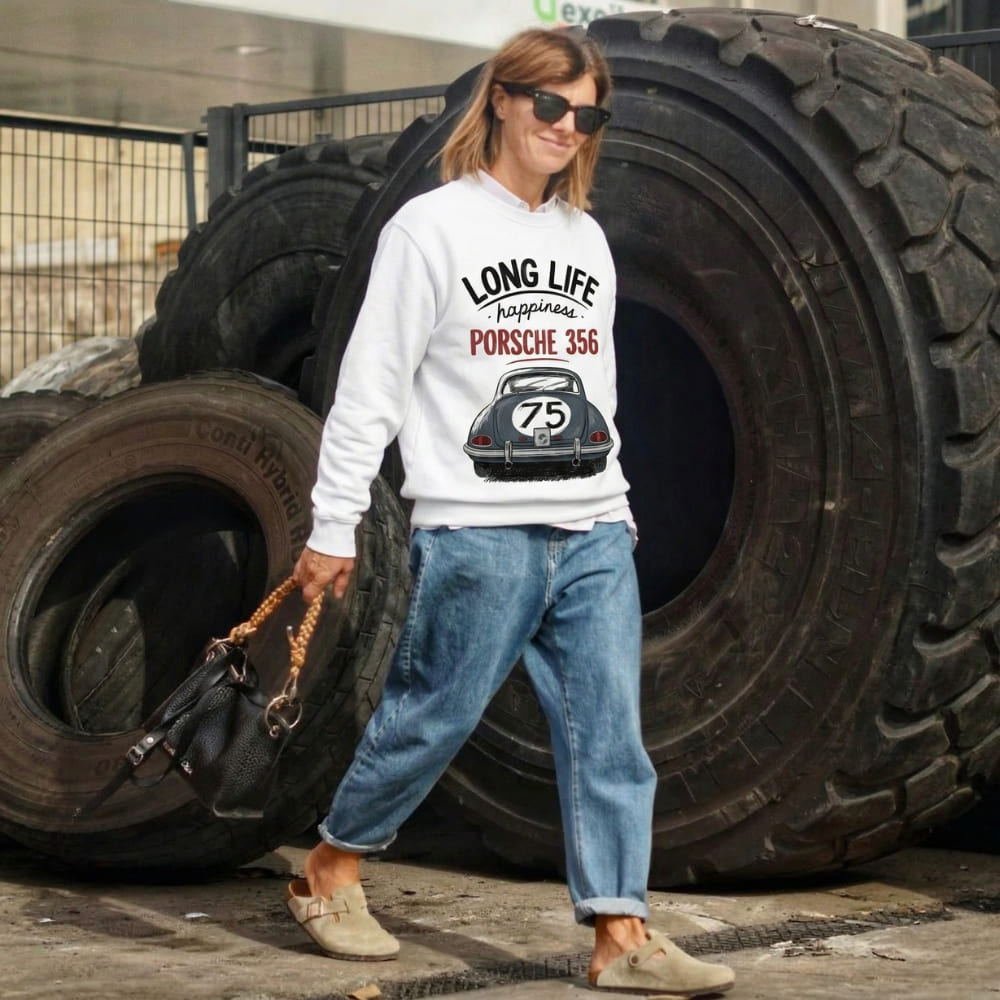 Person wearing a white sweatshirt with Porsche design in an industrial setting