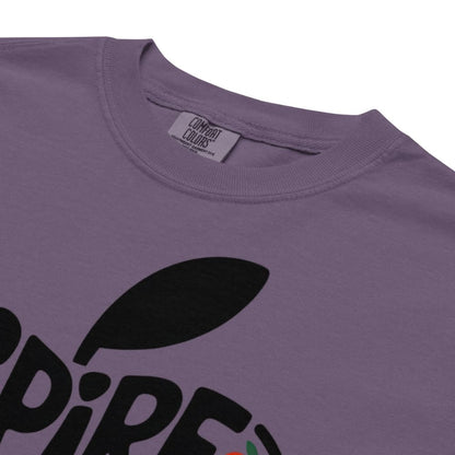 Purple t-shirt with black leaf graphic and brand tag on a white background