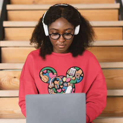 Person wearing a colorful sweatshirt with a design, sitting on steps using a laptop.