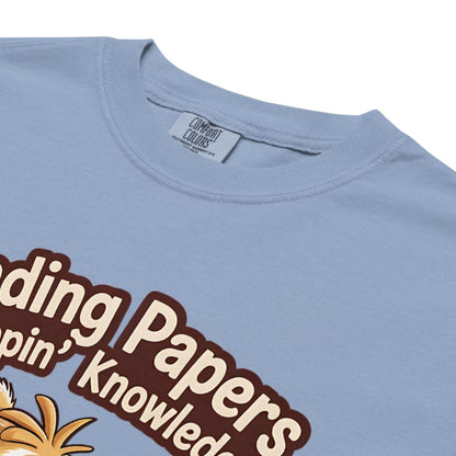 Light blue t-shirt with brown text and a pineapple graphic on a white background