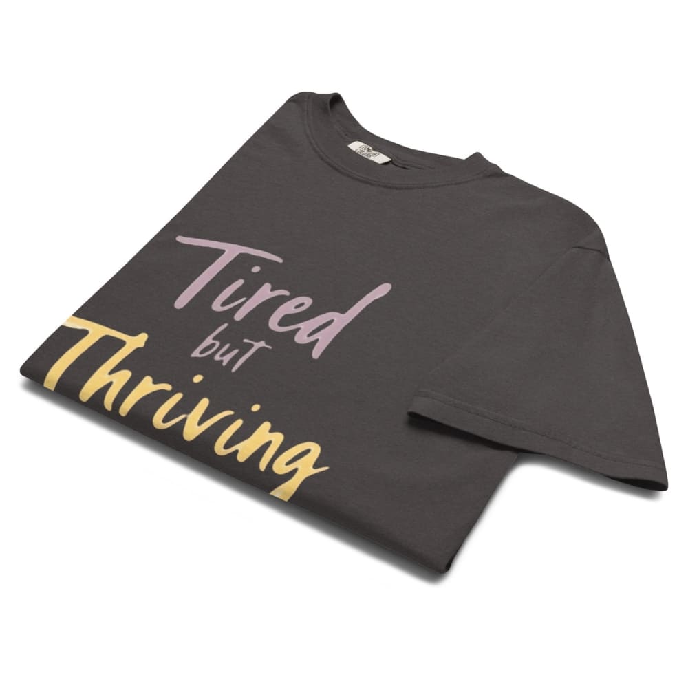Garment-dyed relaxed fit t-shirt with motivational quote “Tired But Thriving” in modern handwritten script