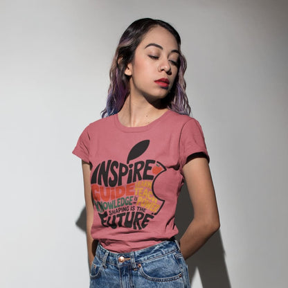 Woman wearing a pink t-shirt with text and graphics, standing against a plain background