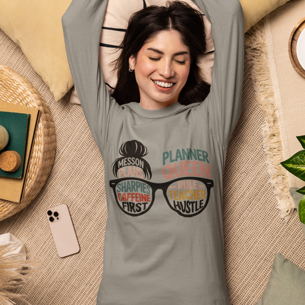 Woman wearing a gray t-shirt with text and graphics, lying on a textured surface.