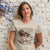 Woman wearing a t-shirt with a cartoon character and text against a textured wall background