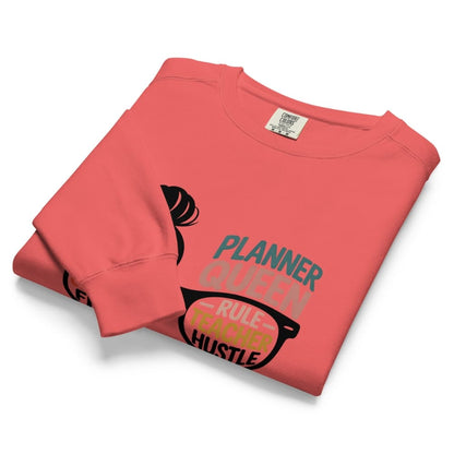 Folded coral sweatshirt with text and graphics on a white background