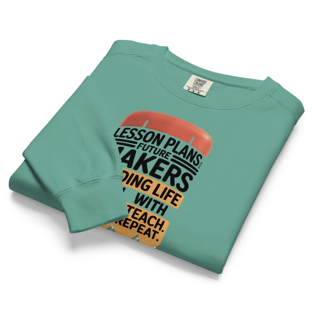 Folded teal sweatshirt with colorful text design on a white background
