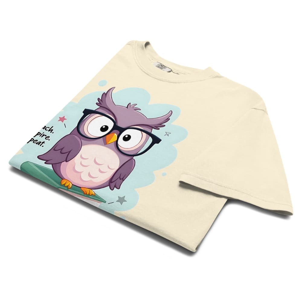 Cute purple owl with glasses sitting on stacked books, with quote "Teach. Inspire. Repeat." – printed on a teacher t-shirt