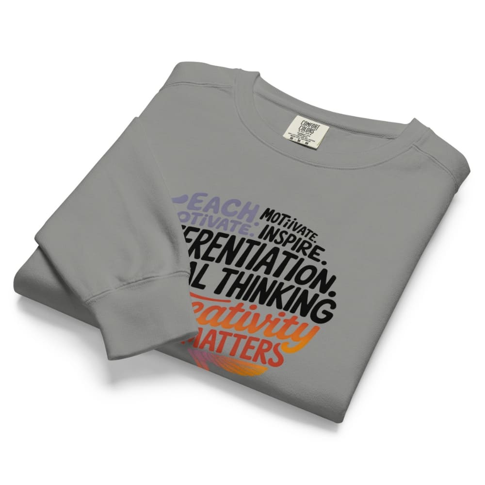 Folded gray sweatshirt with motivational text on a white background